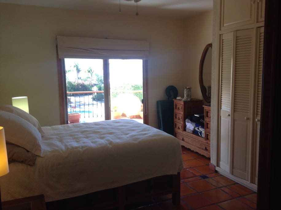 Second bedroom with queen sized bed, patio access and adjacent bathroom.