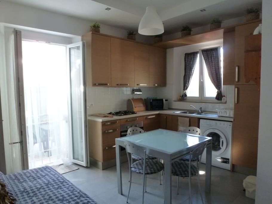 Angolo cucina con accesso a cortile esterno e divano letto