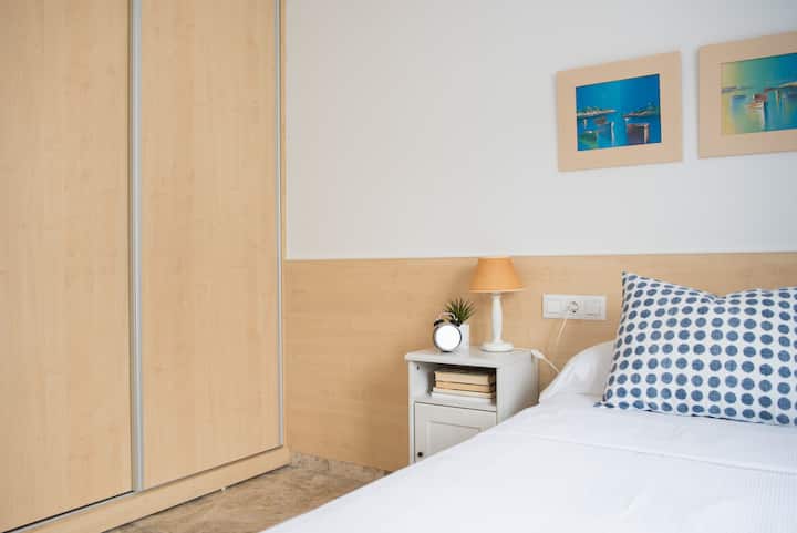 卧室配有简单的床和衣柜