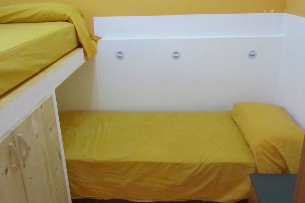 Stanza con letto a castello, comodino e armadietto