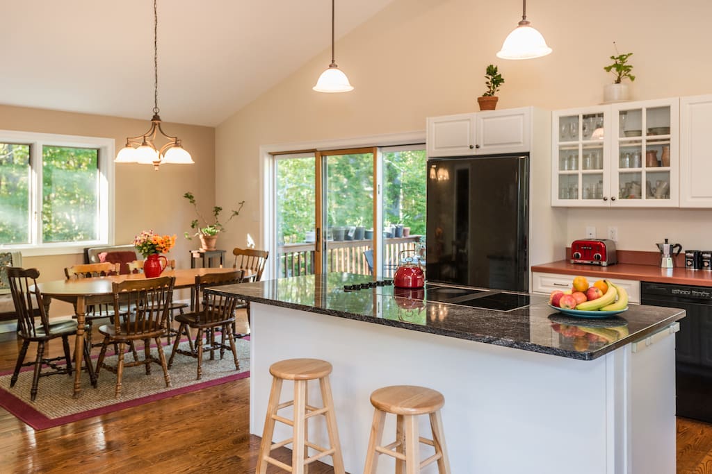 An open kitchen design with vaulted ceilings, a bar and dining table