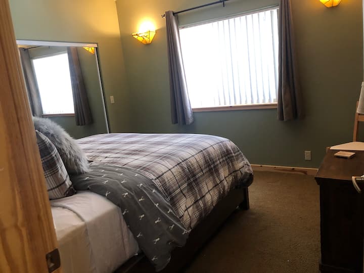 Dormitorio principal con una acogedora cama California King con colchón y ropa de cama nuevos. ¡Las cortinas opacas te permiten dormir!