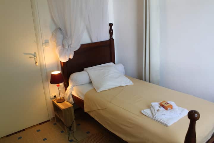 تقع غرفة النوم الثالثة بسرير واحد على الجانب الآخر من غرفة المعيشة وتطل أيضًا على جزء آخر من الحديقة