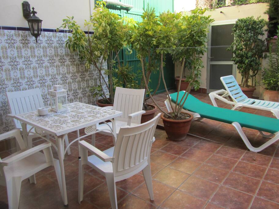 Terrasse mit Sitzgruppe und Liegen vor dem eigenen Eingang zum eigenen Parkplatz