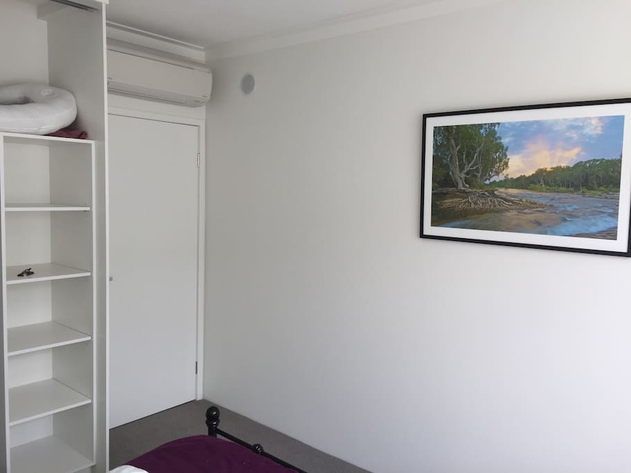 AC unit, beautiful picture of nature and shelves to separate your clothes