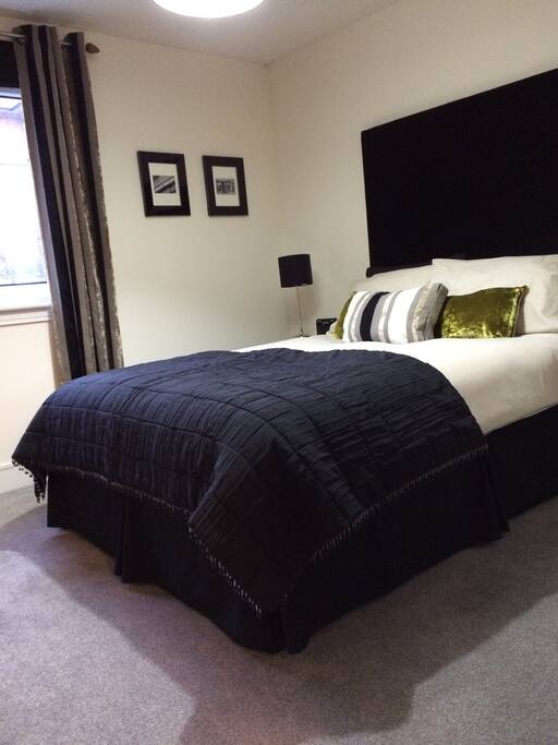 Good-sized main bedroom with luxurious headboard and good quality furnishings