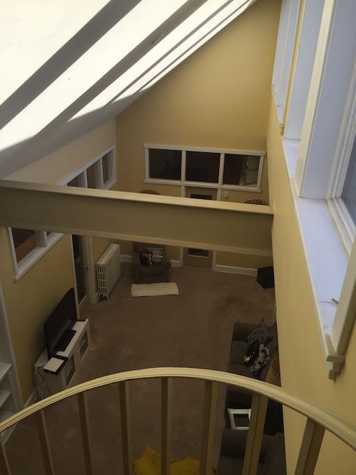 View of living room from the top of spiral steps. Steps lead to the outdoor space