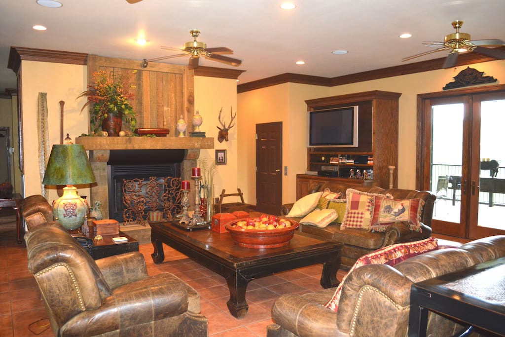 The massive great room has a fireplace, big screen TV, 4 sofas, and even more seating. there is a self-playing Baby Grand piano, and a wrap-around screen porch.