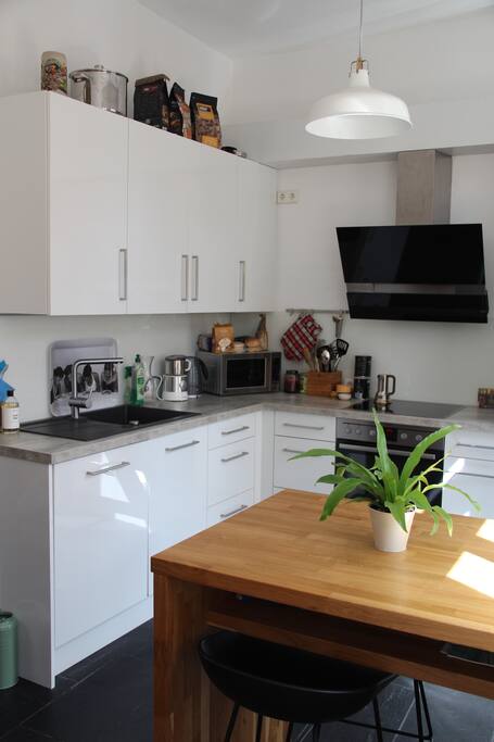 The kitchen has a dish-washer, a microwave, a toaster and an oven