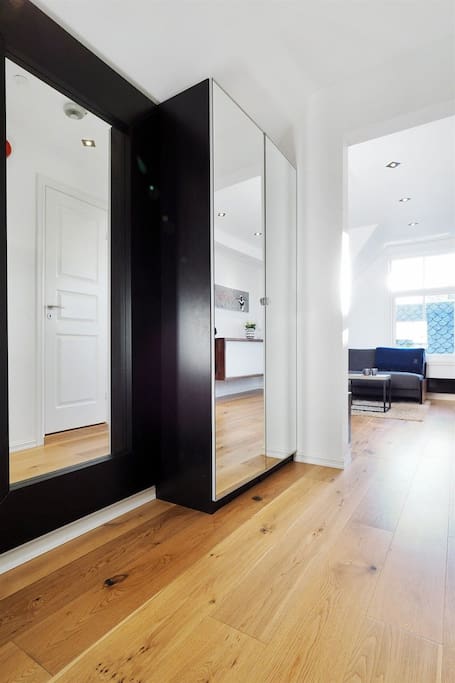 The entrance comes with two mirrored closets where you have more than enough space for your outerwear.