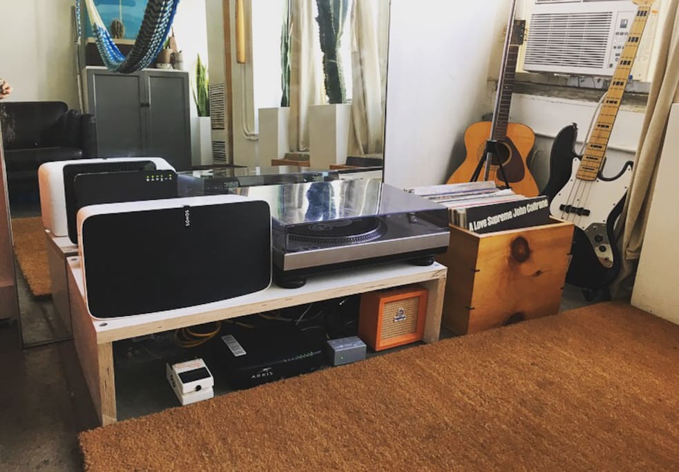 Sonos sound system with record player, collection and guitars