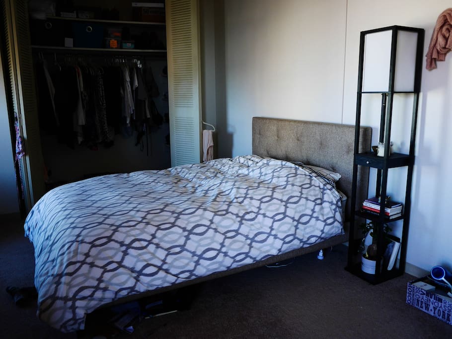 Full-sized bed with large closet and tucked-in shelves