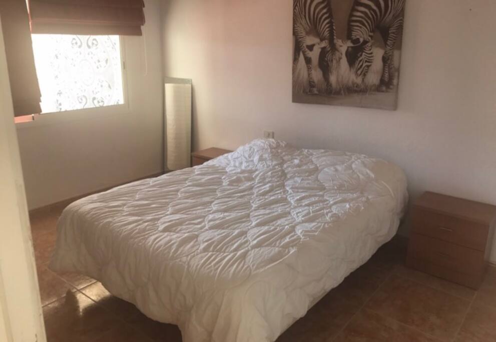 Habitación con cama matrimonial y luminosa .