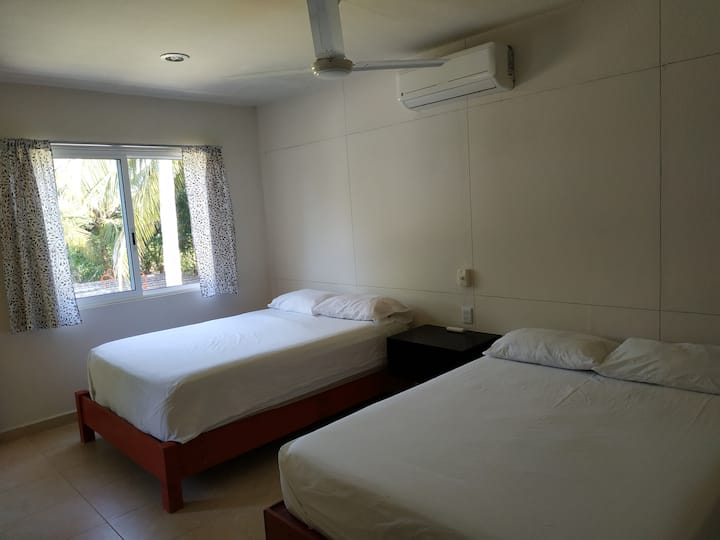 Habitación planta alta, con dos camas matrimoniales, baño completo y clima.