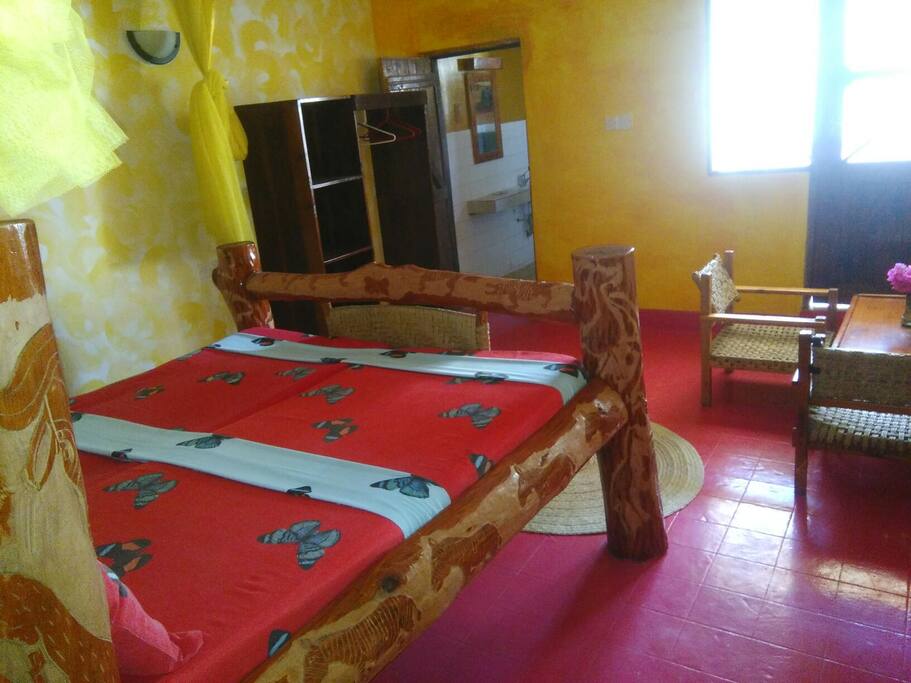 view of the room with the bed, wardrobe, bathroom door, windows and balcony door as well.