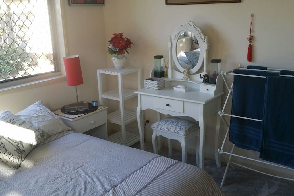 Tidy bedroom including air conditioner, fan, security screens, safe, fresh sheets, towels, soap, alarm clock and bluetooth speaker.