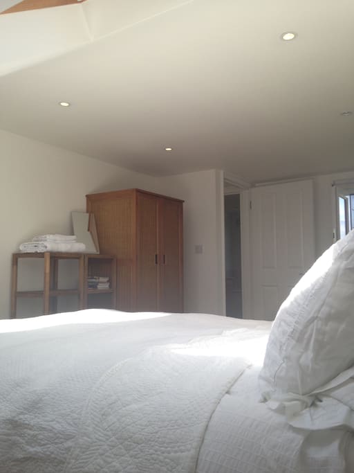 Blackout curtains throughout for a restful sleep. Double bed with white bed linen, down pillows and duvet. Storage space: wardrobe and chest of drawers.