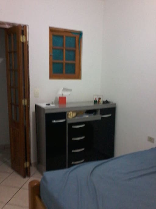 Ainda quarto com cama de casal e cômoda