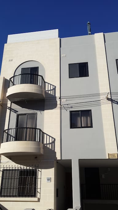 Main Facade of apartment, top floor with front balcony and window.