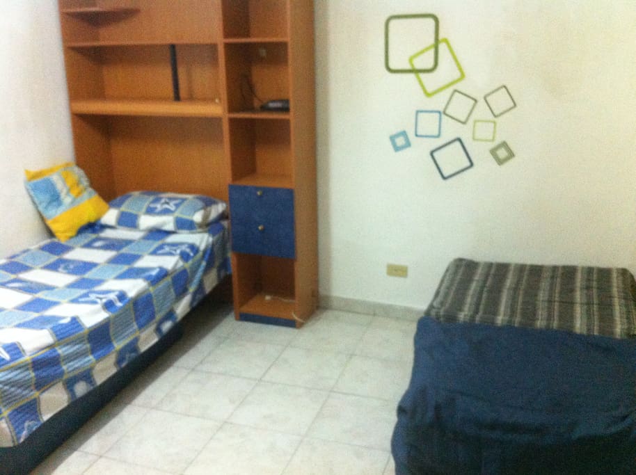 Habitación con cama sencilla y dos camas desarmables. Tv a color privada.