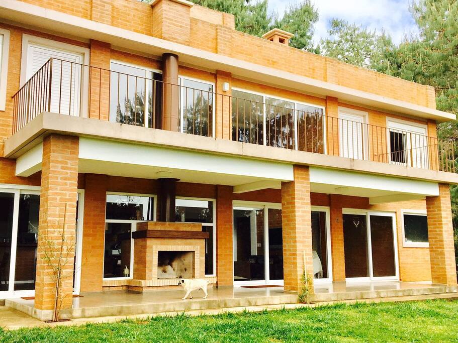 Varanda que unifica as suítes no piso superior e lareira da varanda principal da casa.