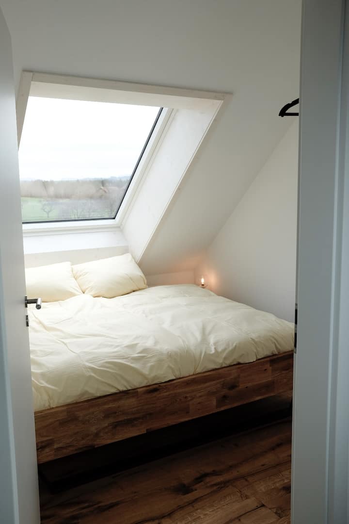 Spálňa s posteľou 2 m x 2 m a strešným oknom s roletou orientovanou na východ