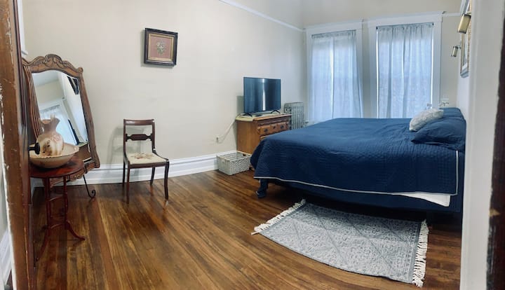 Master Bedroom: king bed, tv, full length mirror, and alarm clock with plug-in for a phone charger. 