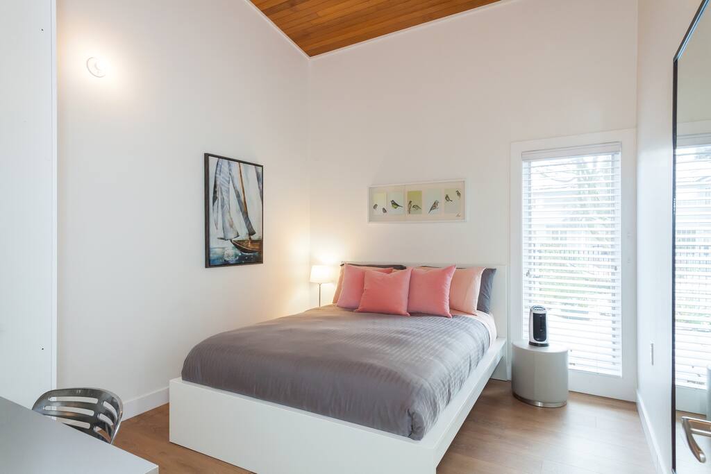 High vaulted ceiling, soothing warm white walls and soft colour palette surrounded by two large airy, vertical windows finished in versatile, uncomplicated wide slatted blinds.