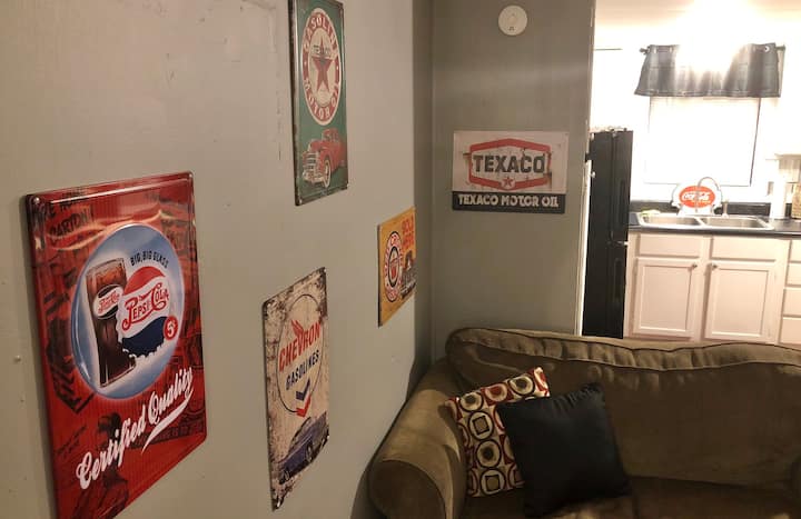 Vintage style tin metal advertising signs of Pepsi and various gas stations give the living room wall some color...