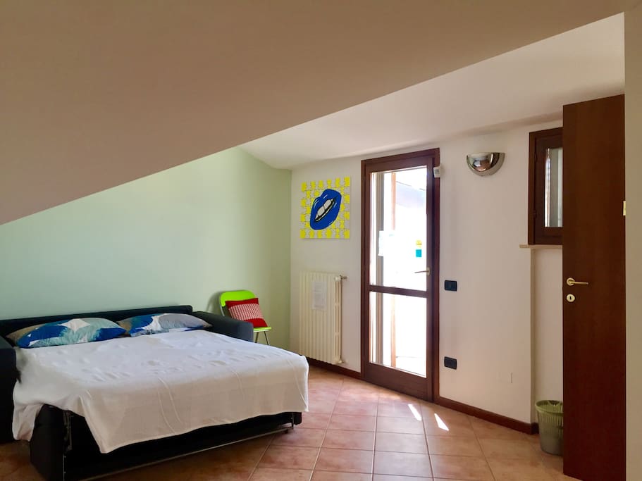 Mansarda adibita a camera da letto per gli ospiti con porta per accedere al terrazzo