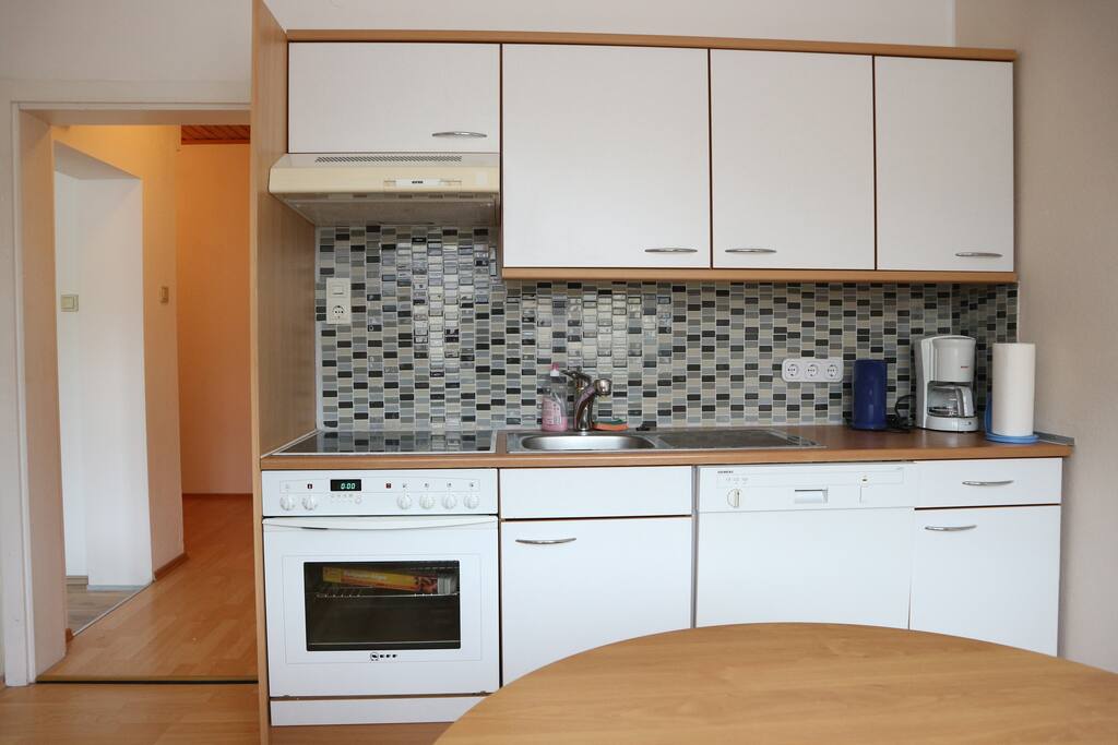 Küche mit Geschirrspüler, E-Herd und Kühlschrank mit Gefrierfach