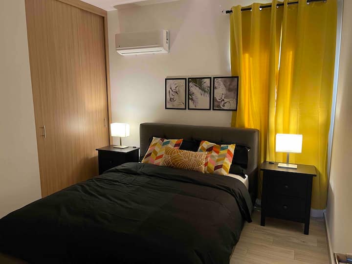 เตียงควีนไซส์พร้อมโต๊ะหัวเตียง 2 ตัวพร้อมโคมไฟตู้เสื้อผ้าในห้องพักกว้างขวางและเครื่องปรับอากาศ