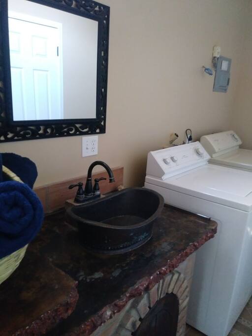 bathroom with a large tub with washer and dryer