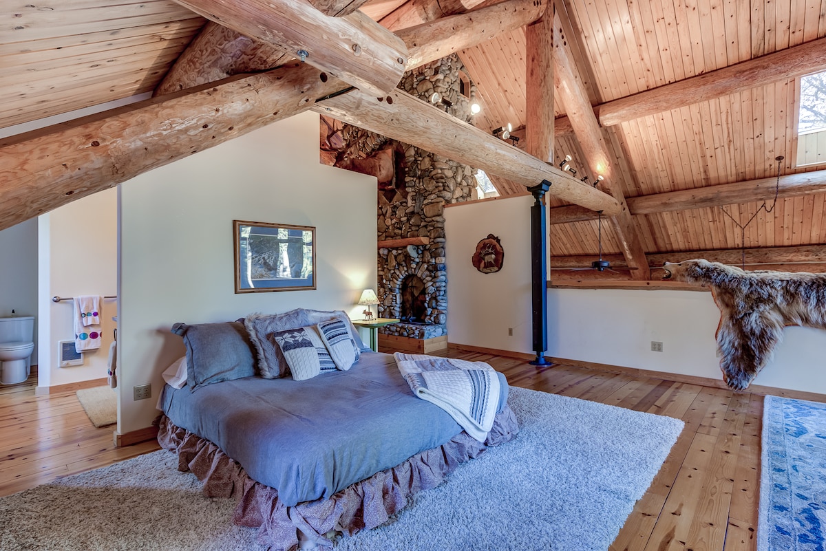 Master bedroom in loft offers a king bed and a wooden crib and attached master bathroom. 