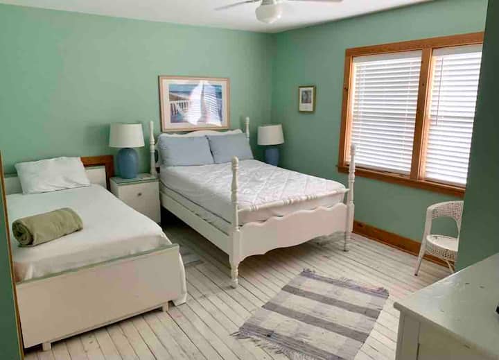 Second-floor bedroom has double and single, original flooring, Window looks east with broken views of ocean