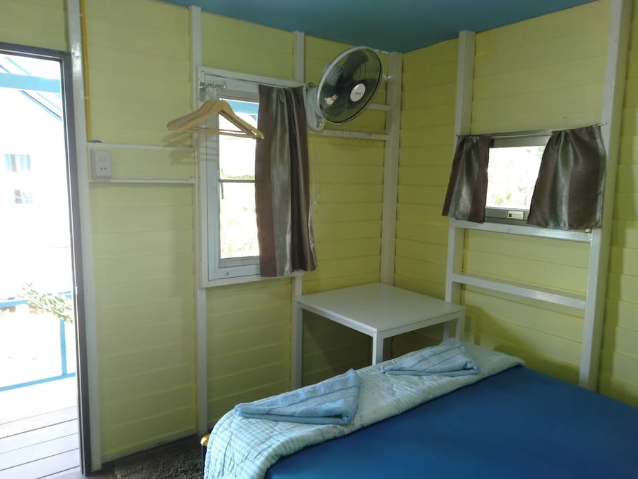 Our clean bright bungalow complete with a comfortable large double bed, a fan, a table for your laptop or other things and some hangers to hang your clothes.