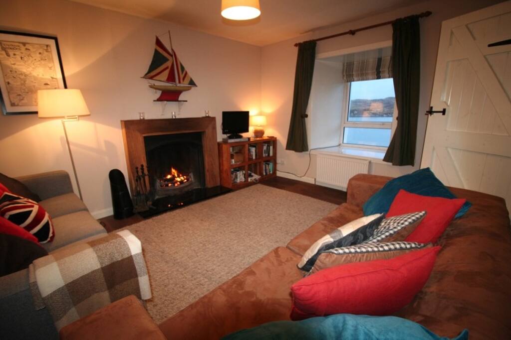 Cosy lounge with large window seat looking out to the sea bay.