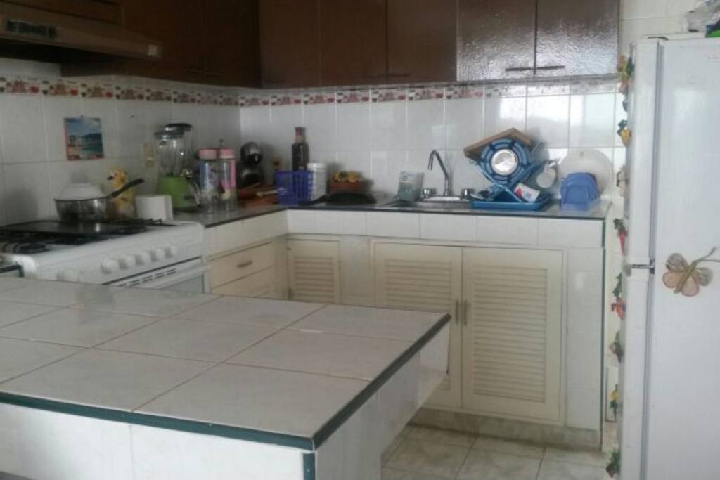 cocina equipada, refrigerador, licuadora, cafetera, platos, cubiertos, estufa.