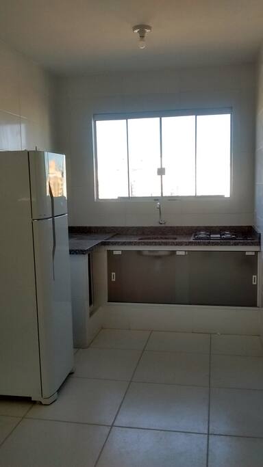 Cozinha completa, com louças, talheres, panelas e panos de prato.