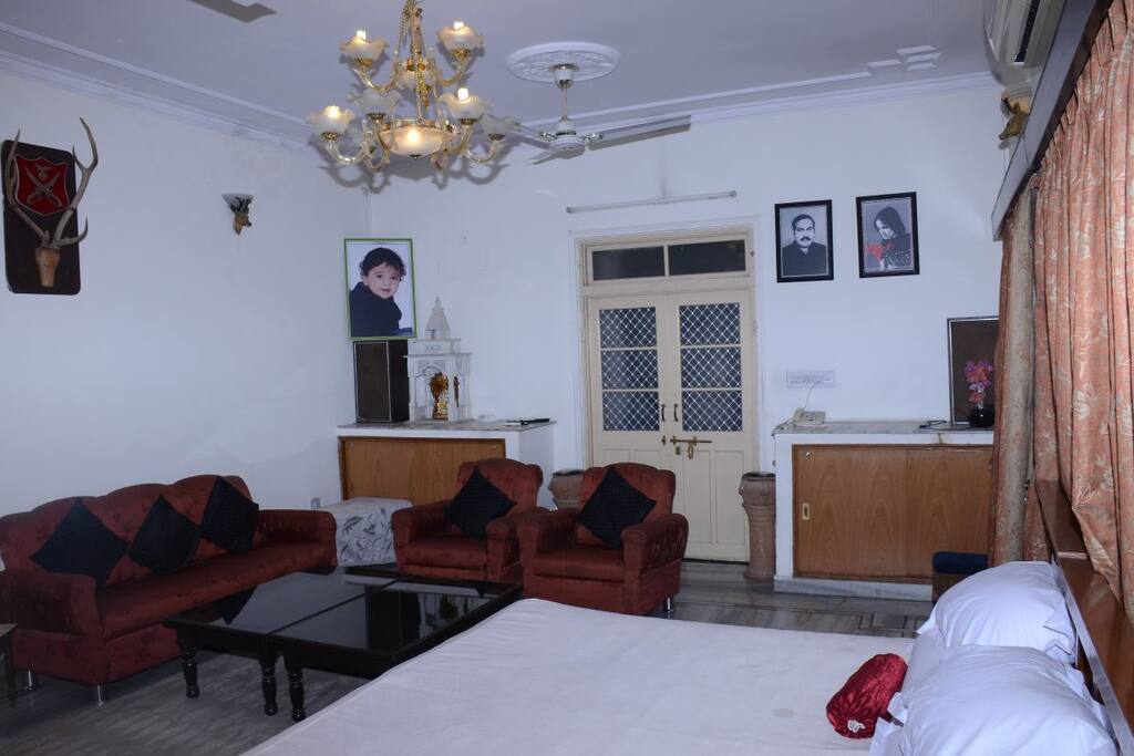 Sofas with centre table gives the feel of suite. Chandelier lit room.