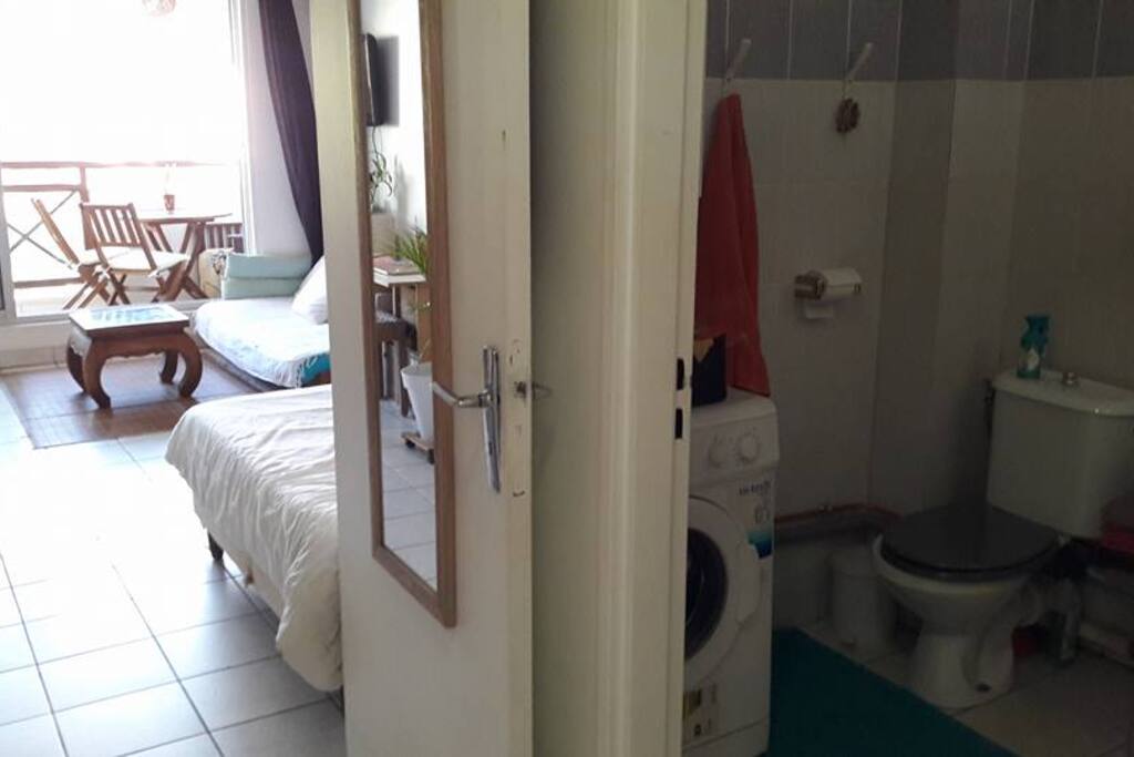 Studio avec cuisine séparée, salle de bain avec baignoire et machine à laver, coin nuit et coin séjour avec varangue