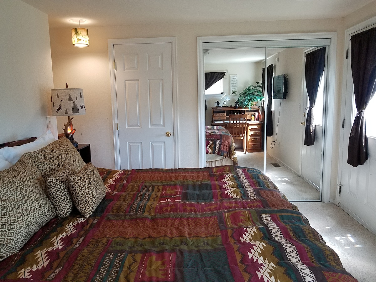 Veľká manželská posteľ so súpravou matracov Simmons Beauty Rest, dvojité nočné stolíky s lampami a zástrčkami USB, písací stôl, skriňa v plnej veľkosti s toaletnými zrkadlami v plnej veľkosti.