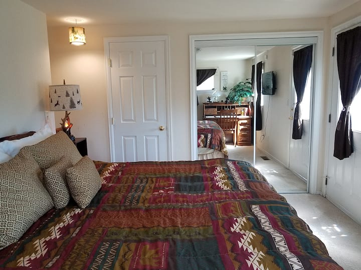 Დიდი ზომის საწოლი Simmons Beauty Rest-ის მატრასით, ორმაგი ტუმბოები ლამპებითა და შტეფსელით, საწერი მაგიდა, სრული ზომის კარადა სრული ზომის გასახდელი სარკეებით.