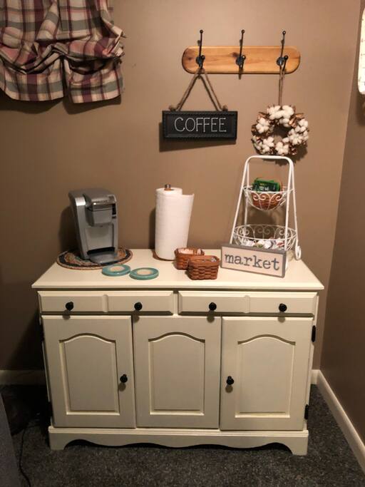 Quaint coffee bar equipped with Keurig coffee maker and variety of coffees including Starbucks.