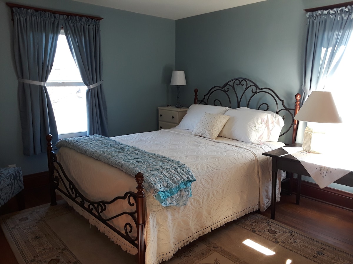 Habitación azul con cama tamaño queen