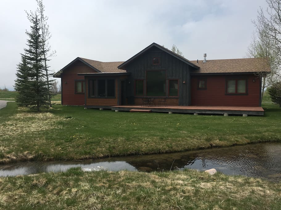 Back of the house and deck. Pond in foreground