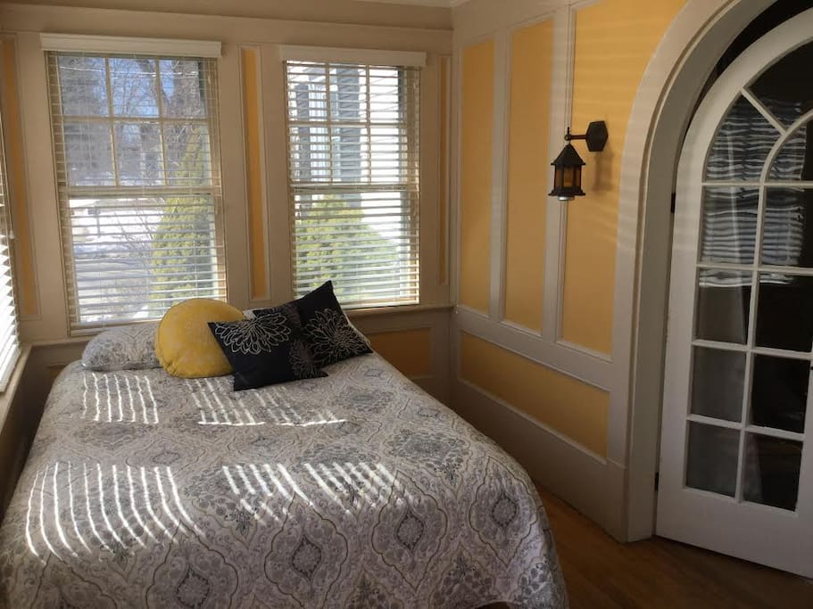A sunroom with queen bed