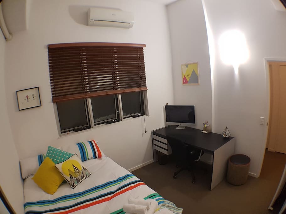 Bedroom with built in robe, air con, queen bed with fresh linen, draws, desk and chair, unlimited wifi, internal facing, ottoman, pedestal fan