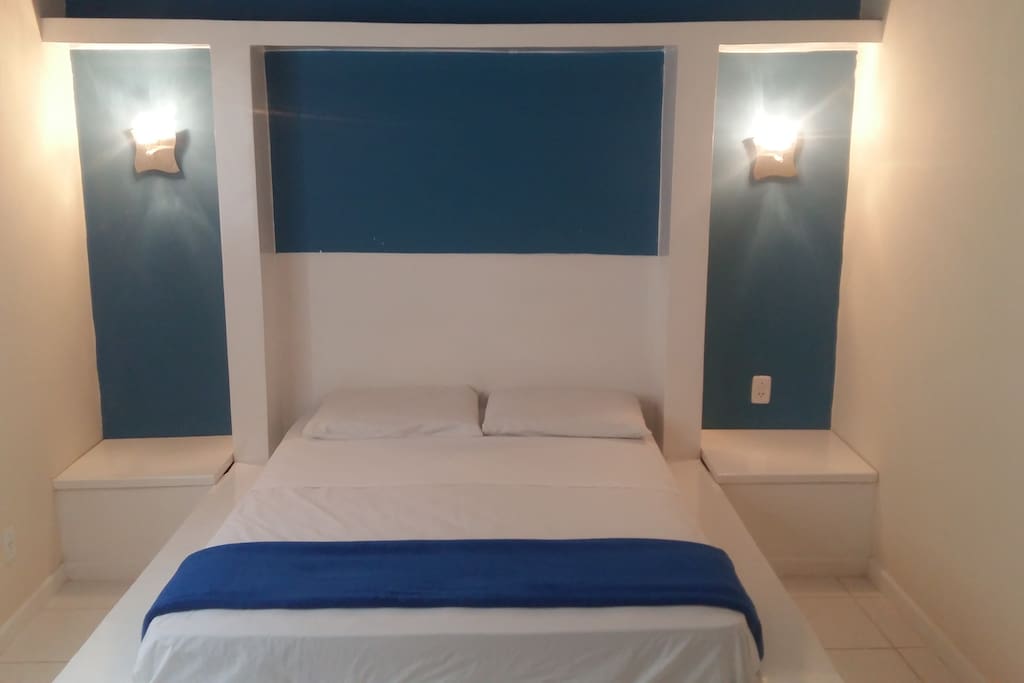 Cama com cabeceira iluminada.