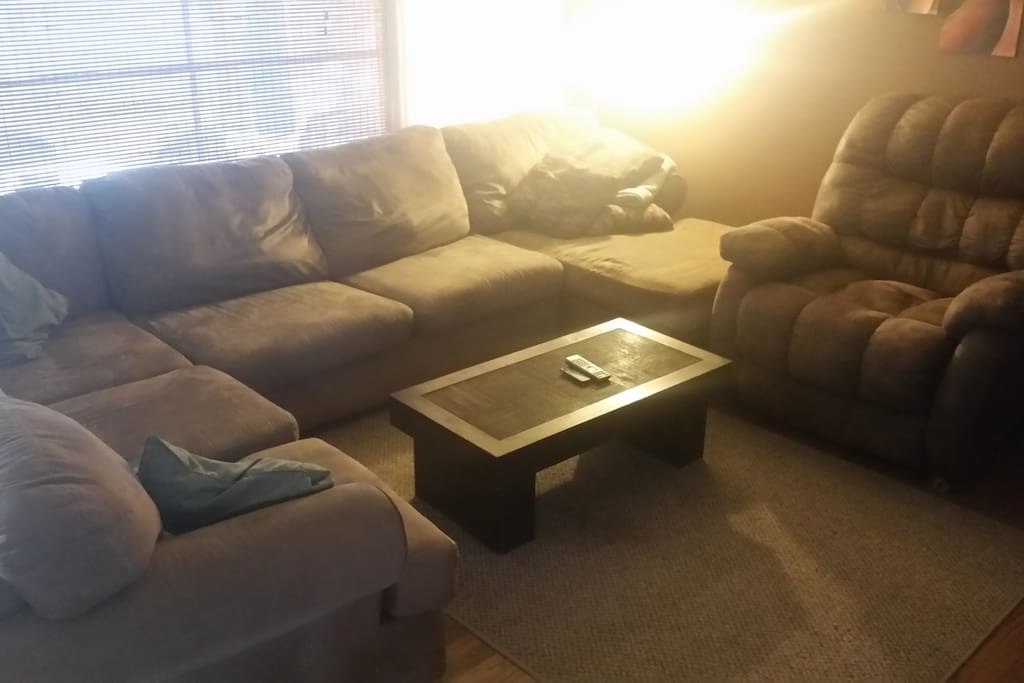 Living room with a sectional couch and a recliner chair for comfort